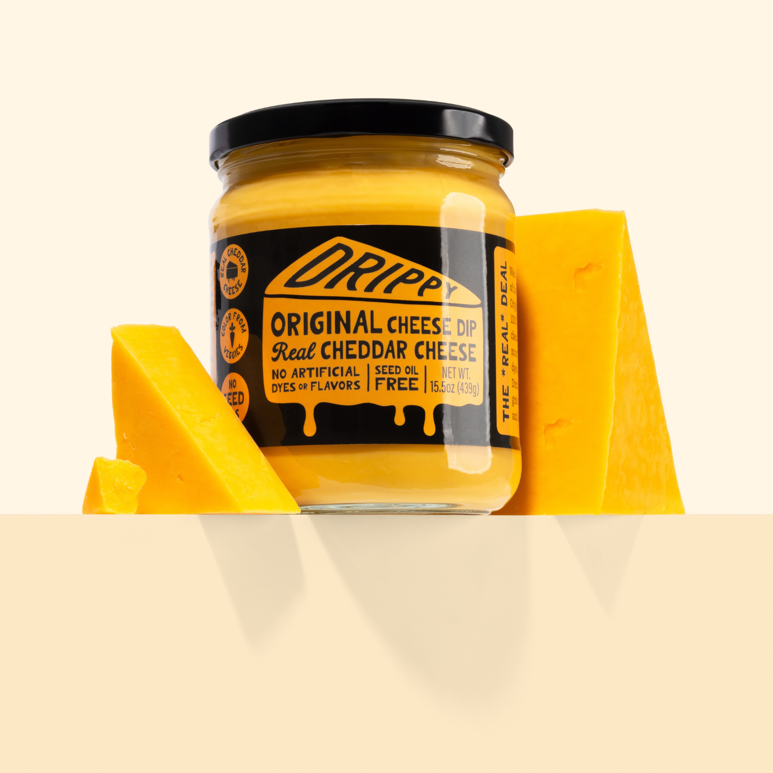 Jar of Dripp Original Cheese Dip with cheddar cheese on a beige background