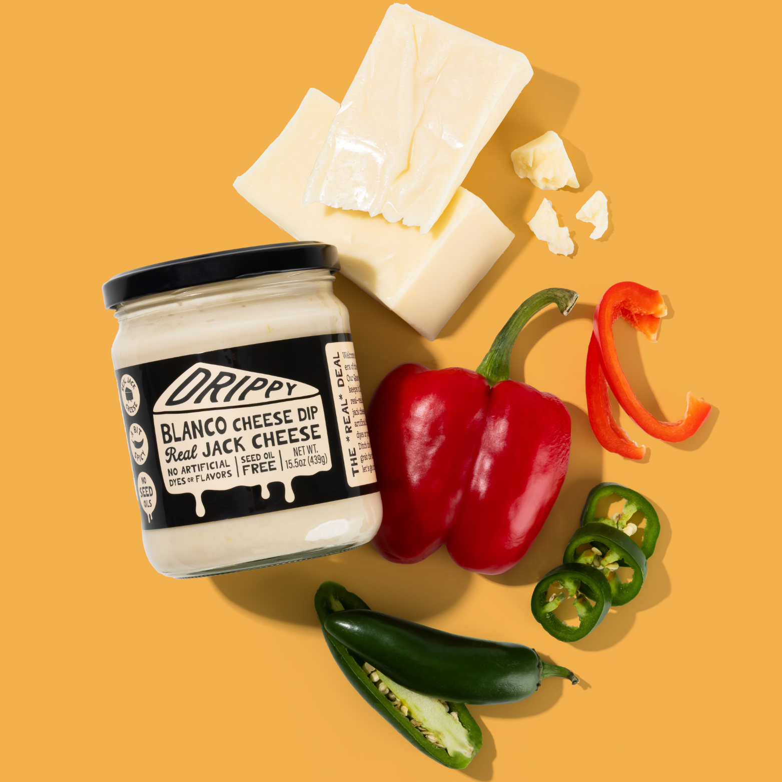 Jar of Drippy Blanco Cheese Dip with cheese, peppers, and jalapeños on a yellow background