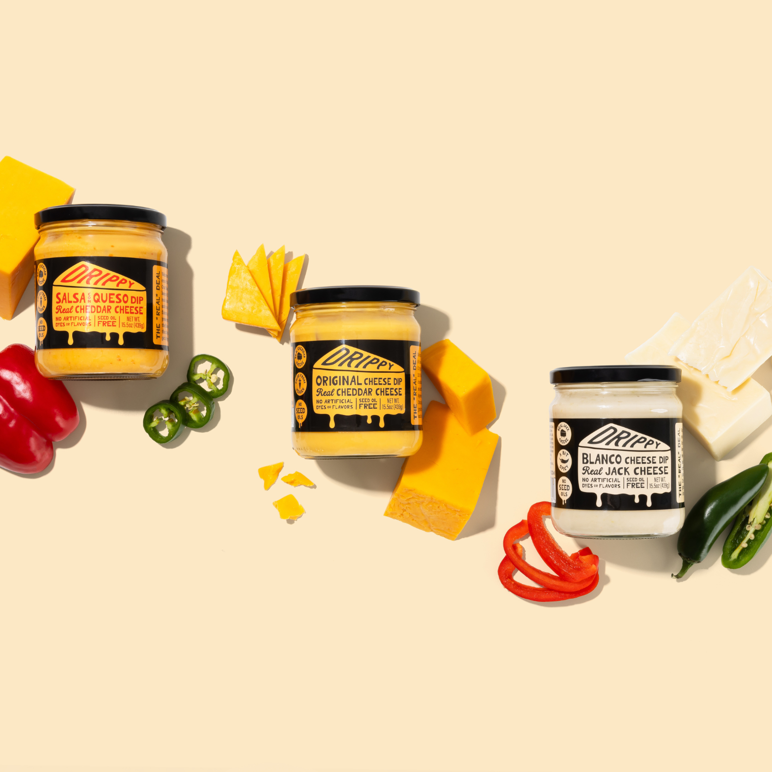 Three jars of Dipsa cheese spread with cheese slices, peppers, and jalapeños on a beige background.