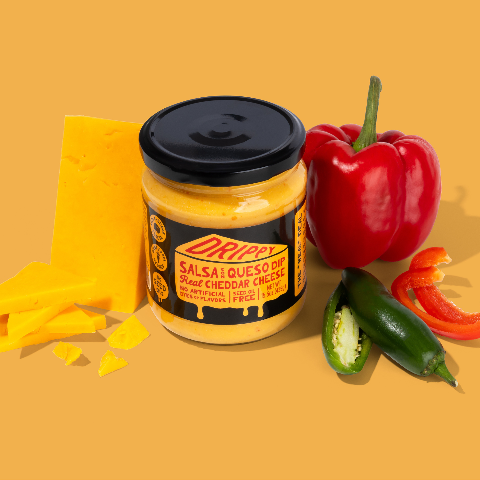 Jar of Drippy Salsa Queso Dip with cheese, peppers, and tortilla chips on a yellow background
